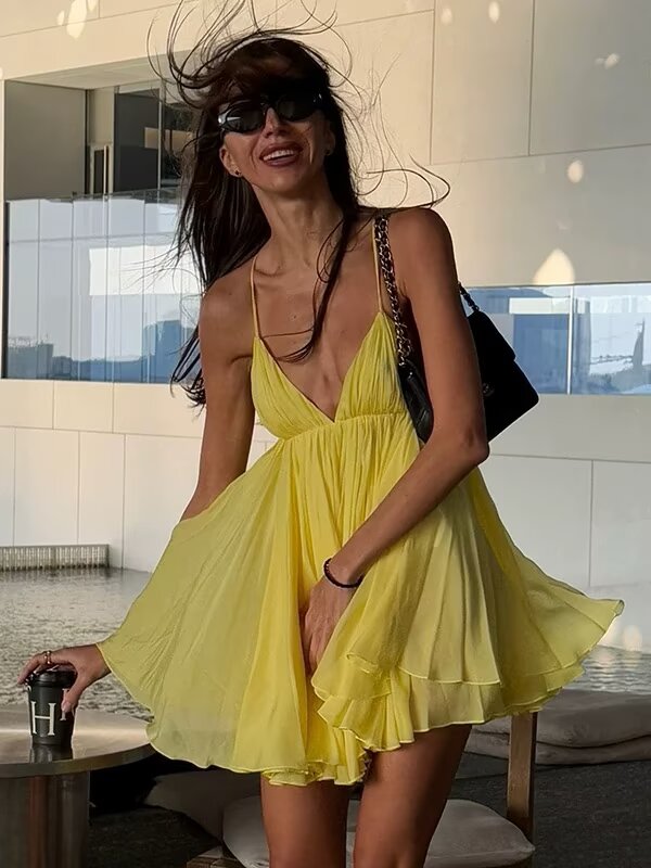 “Woman wearing yellow VIREA A-line lace-up cami dress with V-neck and flowy hem”